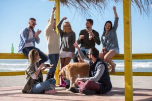 Group of friends having fun on autumn day at beach