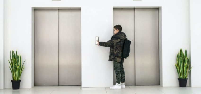 boy-with-casual-clothes-and-white-sneakers-call-the-elevator-white-contemporary-building-interior--1024x674